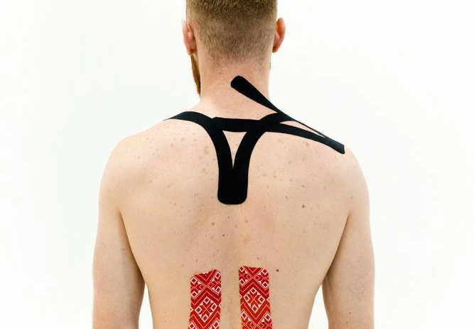 Die Rückseite eines Mannes, die mit Tape an Nacken und Rücken beklebt ist